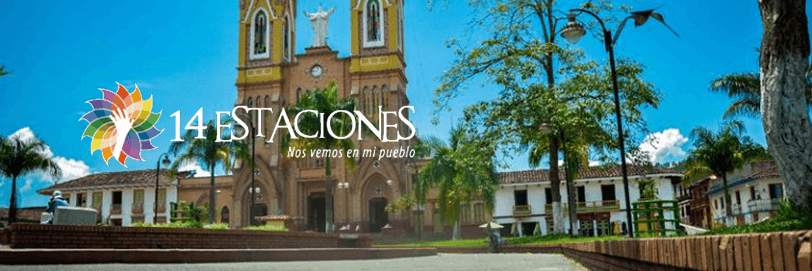 Una luminosa plaza del pueblo con palmeras, caminos de ladrillo y bancos delante de una gran iglesia amarilla; el texto dice "14 EstACIONES Nos vemos en mi pueblo" con un colorido logotipo a la izquierda, destacando las estaciones Marsella.