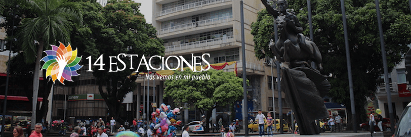 Una concurrida plaza de la ciudad con gente paseando, árboles, una gran escultura moderna y edificios altos. En primer plano se ven globos de colores y el logotipo de 14 estaciones Pereira.