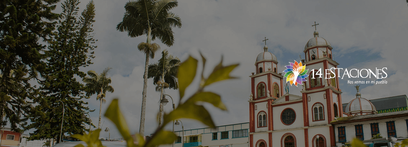 Una iglesia de estilo colonial con detalles rojos y blancos se alza junto a altas palmeras bajo un cielo nublado en Pueblo Rico, Risaralda; el logotipo 14 Estaciones se superpone a la imagen.