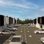 Portal de la Estación es un moderno complejo residencial con dos hileras de edificios blancos con detalles en negro y amarillo, coches aparcados a lo largo de los accesos, plazas de aparcamiento señalizadas y un cielo azul en lo alto.