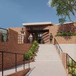 Un moderno edificio de ladrillo con grandes escalones de entrada, barandillas negras y vegetación alrededor. Tres personas suben los escalones hacia la entrada, con árboles y plantas alrededor de la escena bajo un cielo azul.