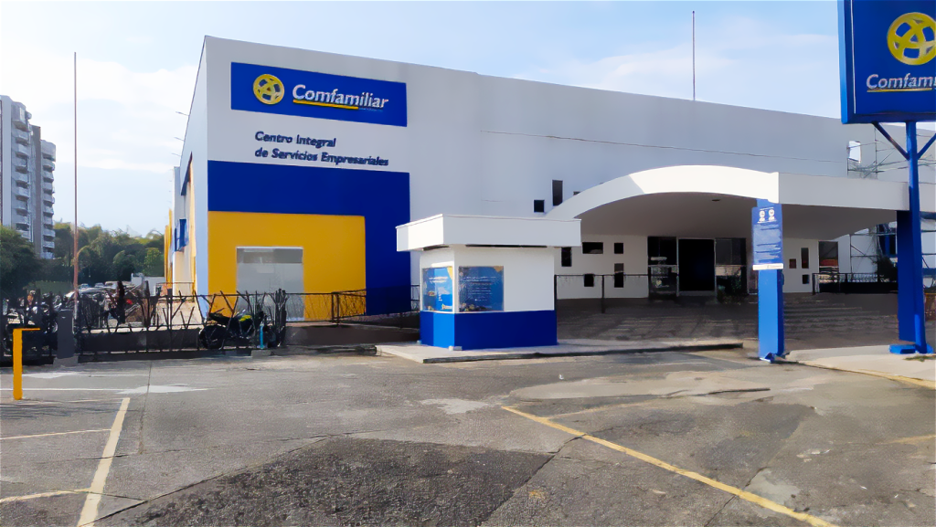 Un moderno edificio con paredes blancas y azules y un cartel que reza Comfamiliar Centro Integral de Servicios Empresariales sobre la entrada ofrece servicios de Gestión Empresarial; enfrente hay un aparcamiento y una rampa accesible.