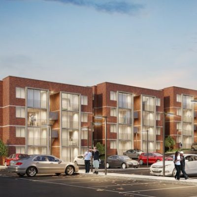 Montebonito Apartamentos ofrece modernos edificios de apartamentos con grandes ventanales y balcones, rodeados de coches aparcados y gente paseando por un aparcamiento, con árboles y un cielo despejado de fondo.
