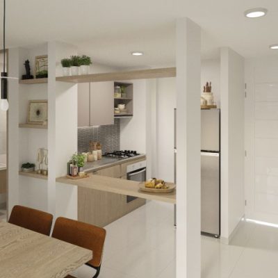 Cocina moderna en Torres del Bosque con paredes blancas y armarios de madera clara, con horno empotrado, cocina de gas, frigorífico de acero inoxidable y decoración minimalista. En primer plano se ve una mesa de comedor con sillas marrones.