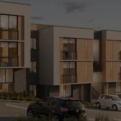 Modernos edificios de apartamentos con balcones al atardecer, varios coches aparcados delante y un cartel de parque canino Villabosque Nativo visible en primer plano.