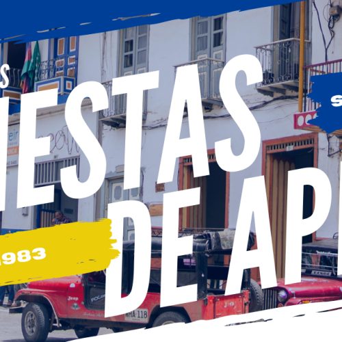 Colorida escena callejera con balcones tradicionales y tuk-tuks, superpuesta con texto promocionando las celebraciones del aniversario de las Fiestas de Apía la semana del 15 de agosto de 1983. En la esquina aparece el logotipo de la Biblioteca Pública Municipal Isaías Naranjo.
